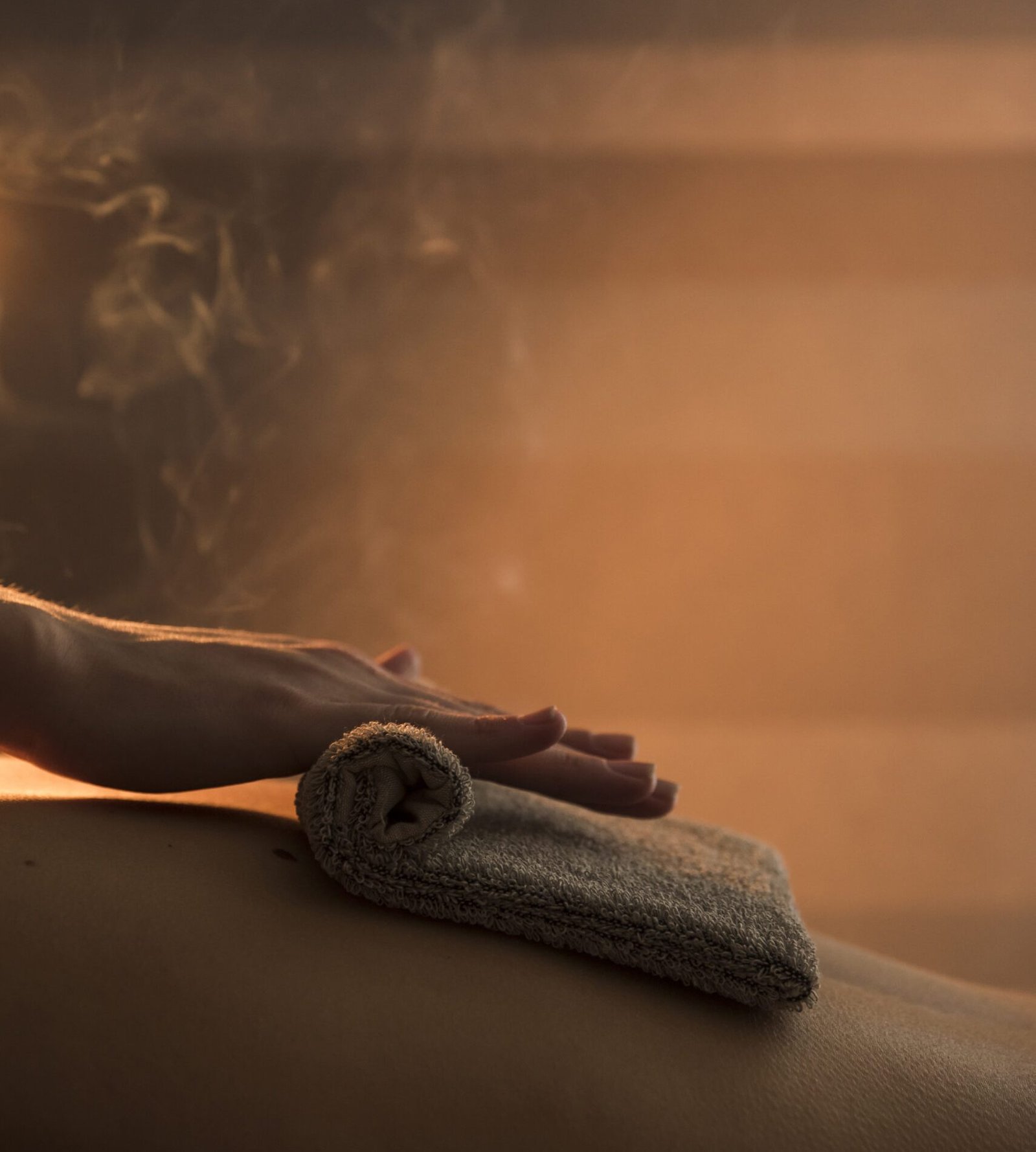 close-up-therapist-hand-massaging-woman-s-back-with-hot-towel-spa